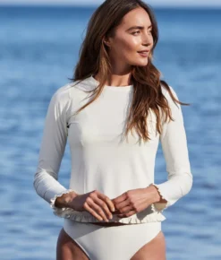 The Waterside Ruffle Rash Guard - White Sand 9 The Waterside Ruffle Rash Guard - White Sand -Summer Salt Swim Store WatersideRuffleRashGuardWhiteSandLifestyle2
